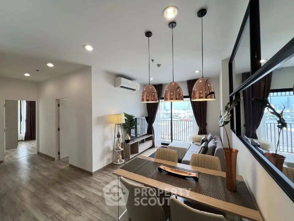 Spacious modern living room with elegant decor and large windows offering stunning city views.