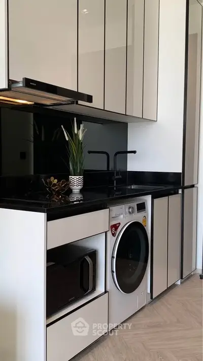 Modern kitchen with sleek cabinetry, built-in appliances, and stylish black countertops.