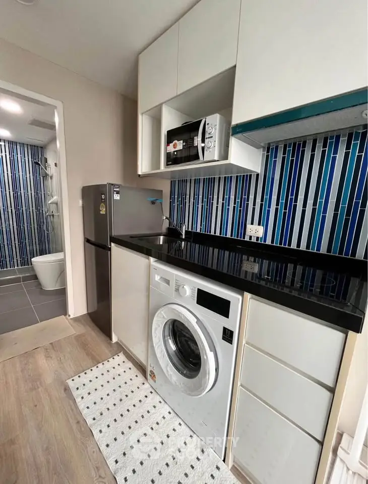 Modern compact kitchen with washing machine and stylish blue backsplash