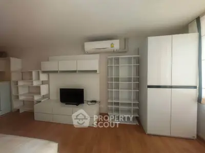 Modern living room with sleek white furniture and air conditioning unit, perfect for urban living.