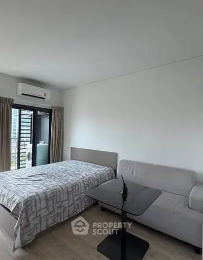 Modern bedroom with bed, sofa, and balcony view in a stylish apartment.