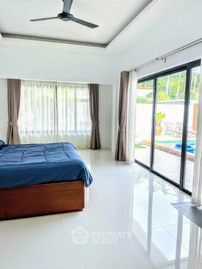 Spacious bedroom with pool view and large windows for natural light