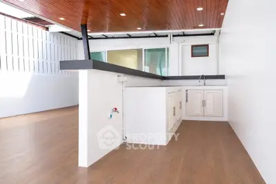 Spacious modern kitchen with sleek wooden ceiling and open layout design.