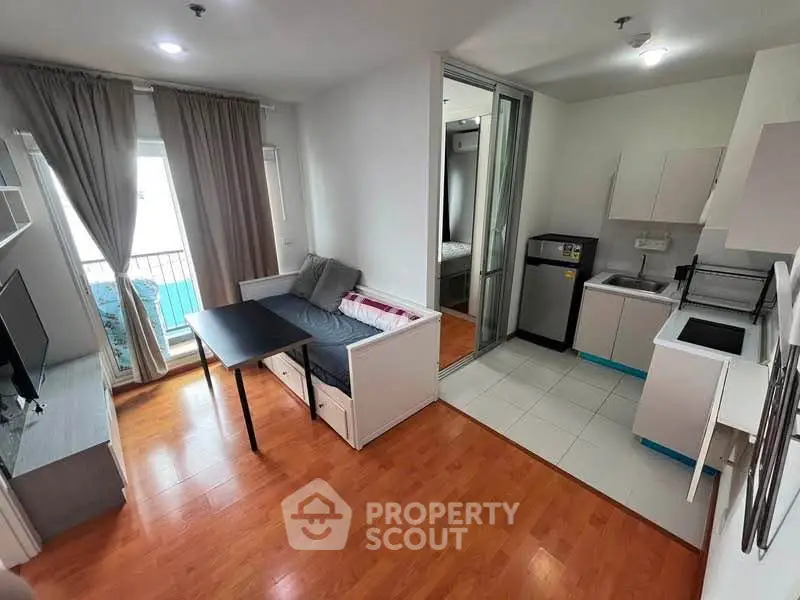 Modern apartment with open layout, featuring a cozy living area and compact kitchen.