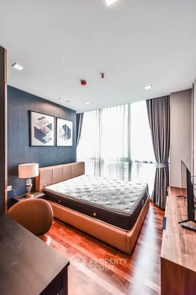 Luxurious bedroom with modern decor and large windows offering natural light