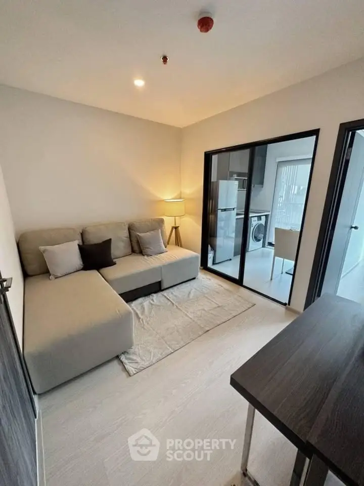 Modern living room with cozy sofa and open kitchen layout in a stylish apartment.