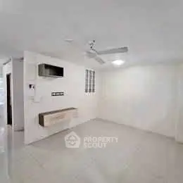 Spacious unfurnished living room with ceiling fan and modern wall unit.