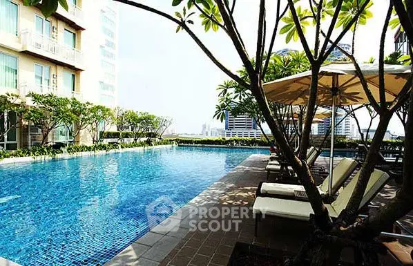 Luxurious rooftop pool with city view and sun loungers, perfect for relaxation.