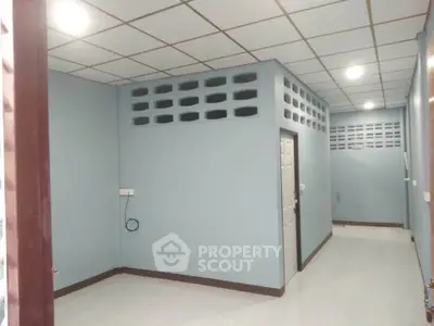 Spacious interior with modern ceiling design and ample lighting, perfect for versatile use.