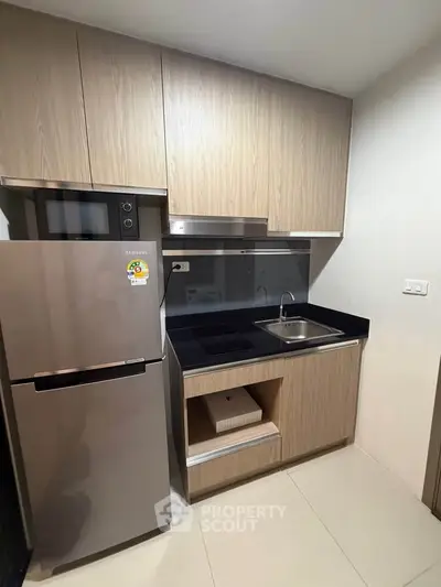 Modern compact kitchen with sleek appliances and wooden cabinetry
