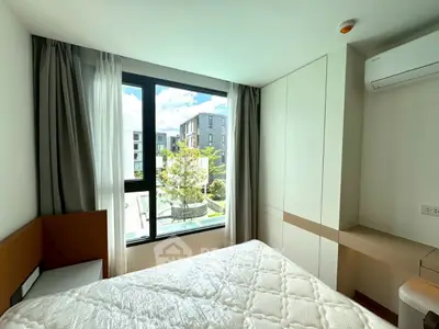 Bright bedroom with large window and modern furnishings in a stylish apartment