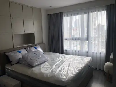 Modern bedroom with city view, featuring stylish decor and natural light for a serene living experience.