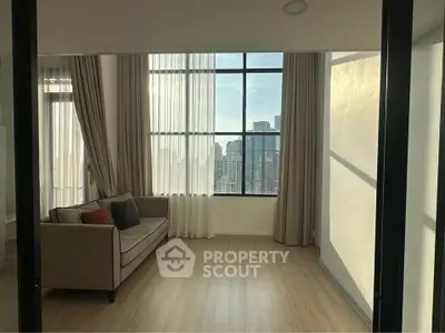 Bright living room with large windows and city view, featuring a cozy sofa and elegant curtains.