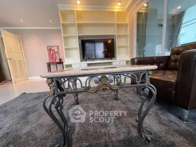 Elegant living room with ornate coffee table and built-in TV shelving, perfect for modern comfort and style.