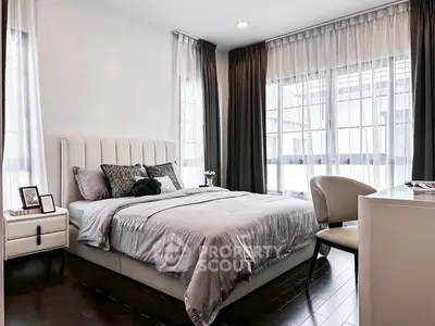 Modern bedroom with elegant decor and large windows for natural light