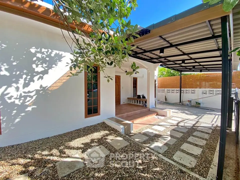 Charming modern house exterior with covered patio and lush greenery