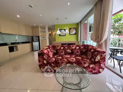 Spacious living room with vibrant floral sofa and modern kitchen in open layout