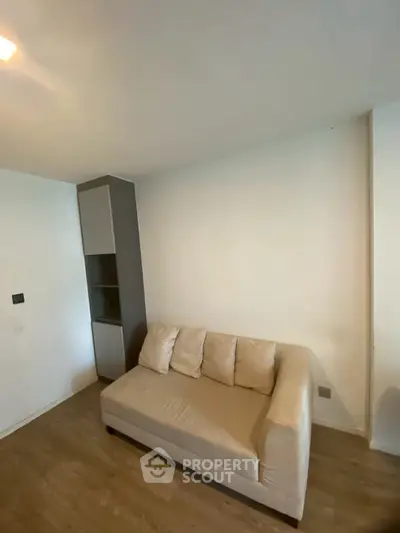 Cozy living room with modern sofa and wooden flooring in a minimalist apartment.