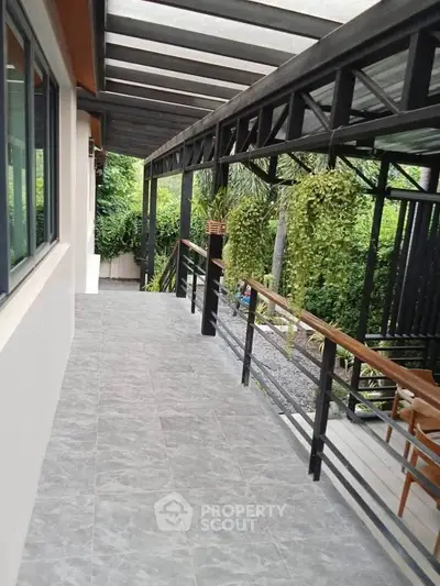 Modern balcony with sleek railing and lush greenery view