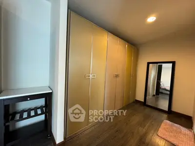 Spacious bedroom with large wardrobe and elegant wooden flooring