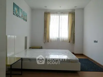 Spacious bedroom with large window and modern minimalist decor