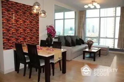 Modern living room with dining area and city view, featuring stylish decor and ample natural light.