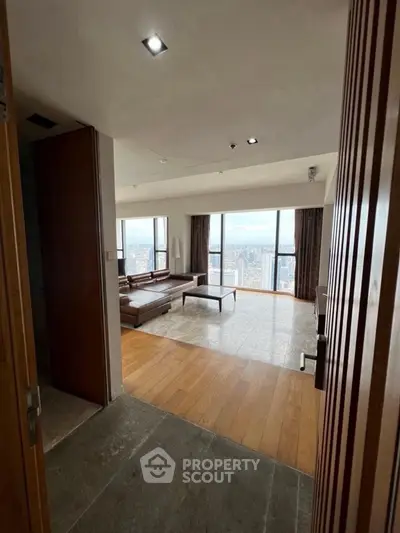 Luxurious living room with panoramic city views and elegant wooden flooring.