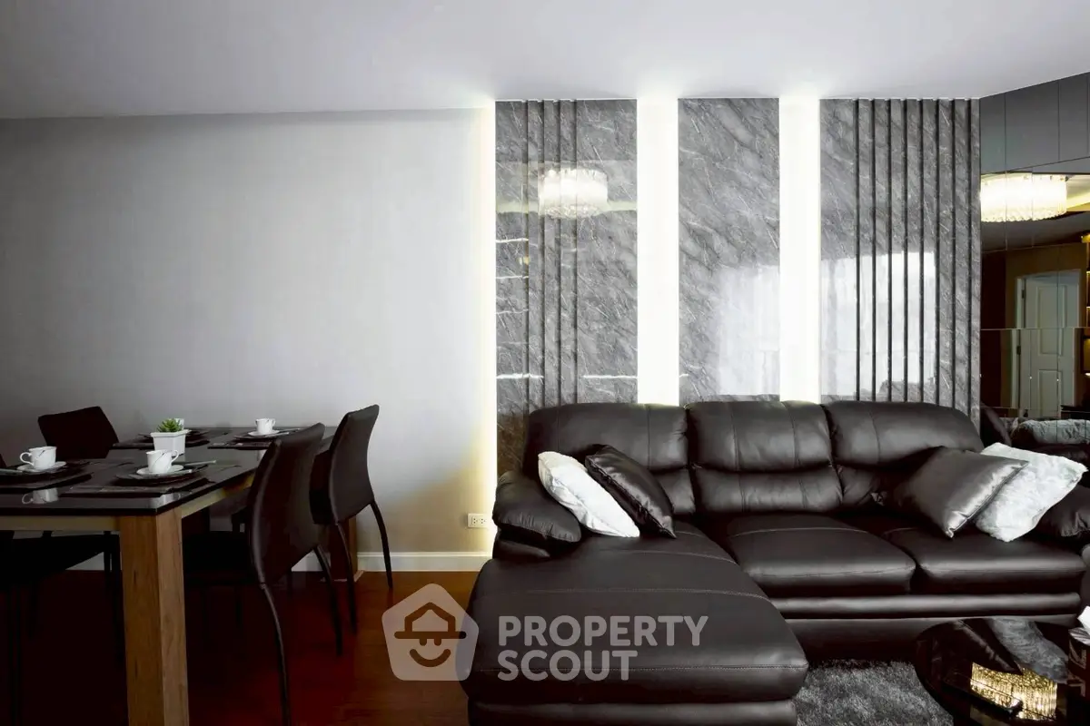 Luxurious modern living room with elegant black leather sofa and stylish dining area.