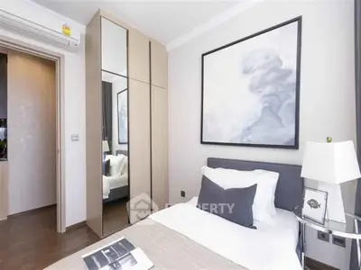 Modern bedroom with stylish decor and mirrored wardrobe in a cozy apartment.