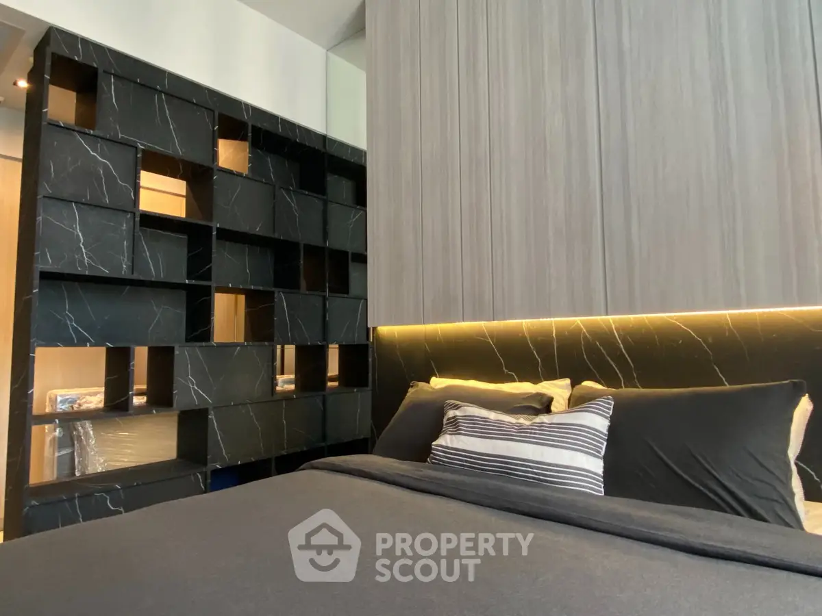 Modern bedroom with stylish black marble accent wall and cozy bedding