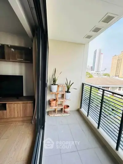Modern apartment balcony with city view and stylish plant decor