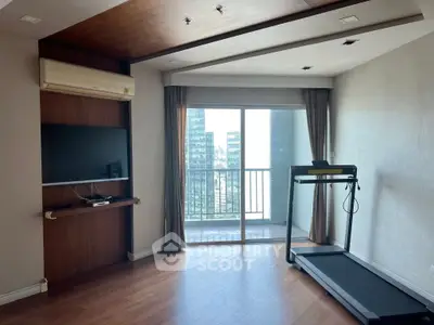 Spacious living room with treadmill and balcony view in modern apartment