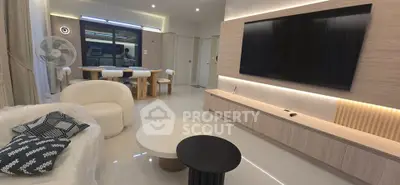 Modern living room with sleek furniture and large TV, perfect for relaxation and entertainment.