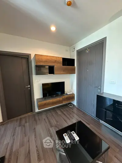 Modern living room with sleek wooden flooring and stylish wall-mounted TV unit.