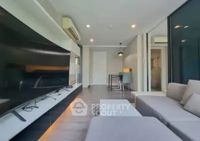 Modern living room with sleek design, large TV, and comfortable seating in a stylish apartment.