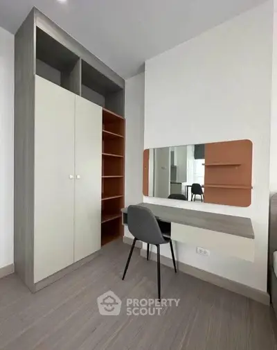 Modern study room with sleek desk, chair, and built-in storage in contemporary apartment.