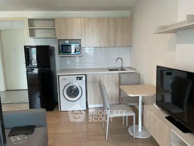 Modern compact kitchen with washing machine and dining area in cozy apartment