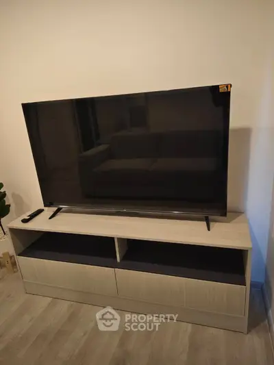 Modern living room with sleek TV stand and large flat-screen TV, perfect for entertainment.