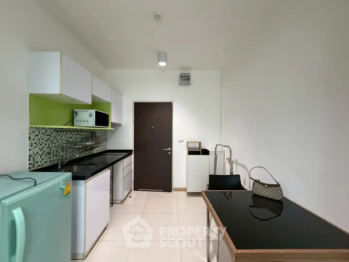 Modern compact kitchen with sleek cabinets and appliances in a minimalist design
