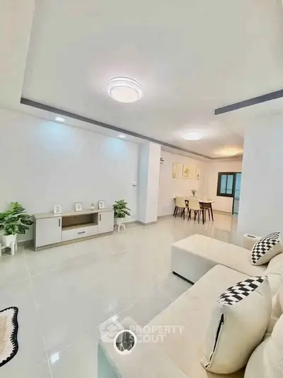 Spacious modern living room with elegant decor and open dining area, perfect for family gatherings.