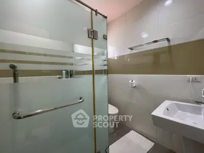 Modern bathroom with frosted glass shower and sleek fixtures