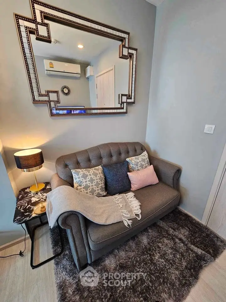 Chic living room with stylish sofa, elegant mirror, and cozy decor accents