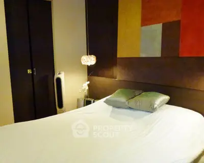 Modern bedroom with stylish decor and cozy ambiance, featuring a comfortable bed and contemporary art.