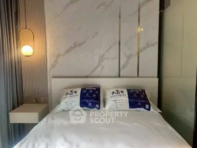 Modern bedroom with elegant lighting and marble accent wall