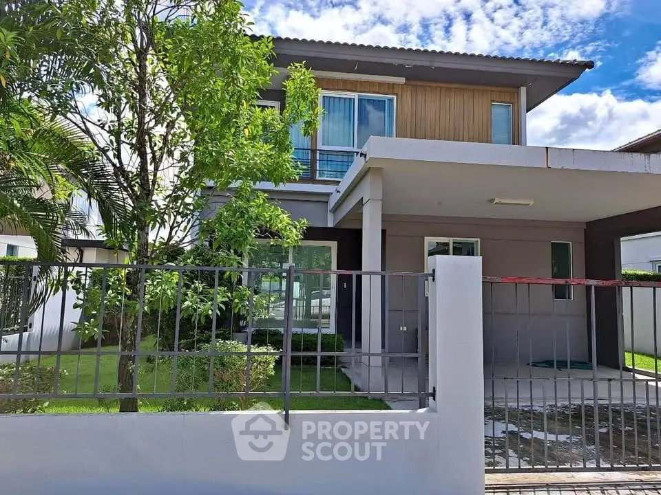 Modern two-story house with lush garden and sleek exterior design.
