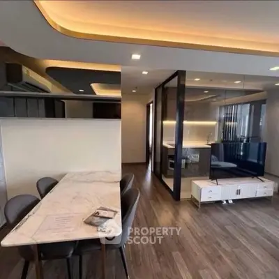 Modern open-plan living room with stylish dining area and sleek kitchen design.