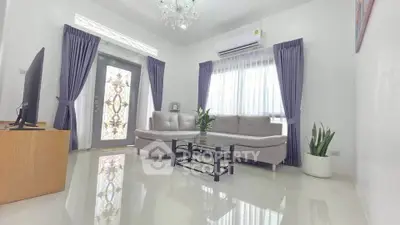 Elegant living room with modern decor, featuring a plush sofa, stylish curtains, and a chic chandelier.