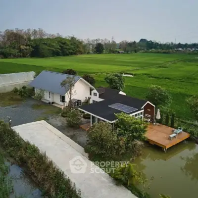 Charming countryside home with solar panels and lush green surroundings.