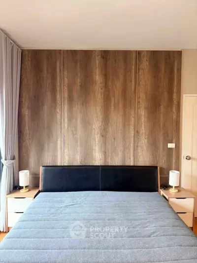 Modern bedroom with stylish wood panel accent wall and cozy bed setup.