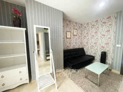 Chic living room with modern decor and stylish wallpaper, featuring a sleek black sofa and glass coffee table.
